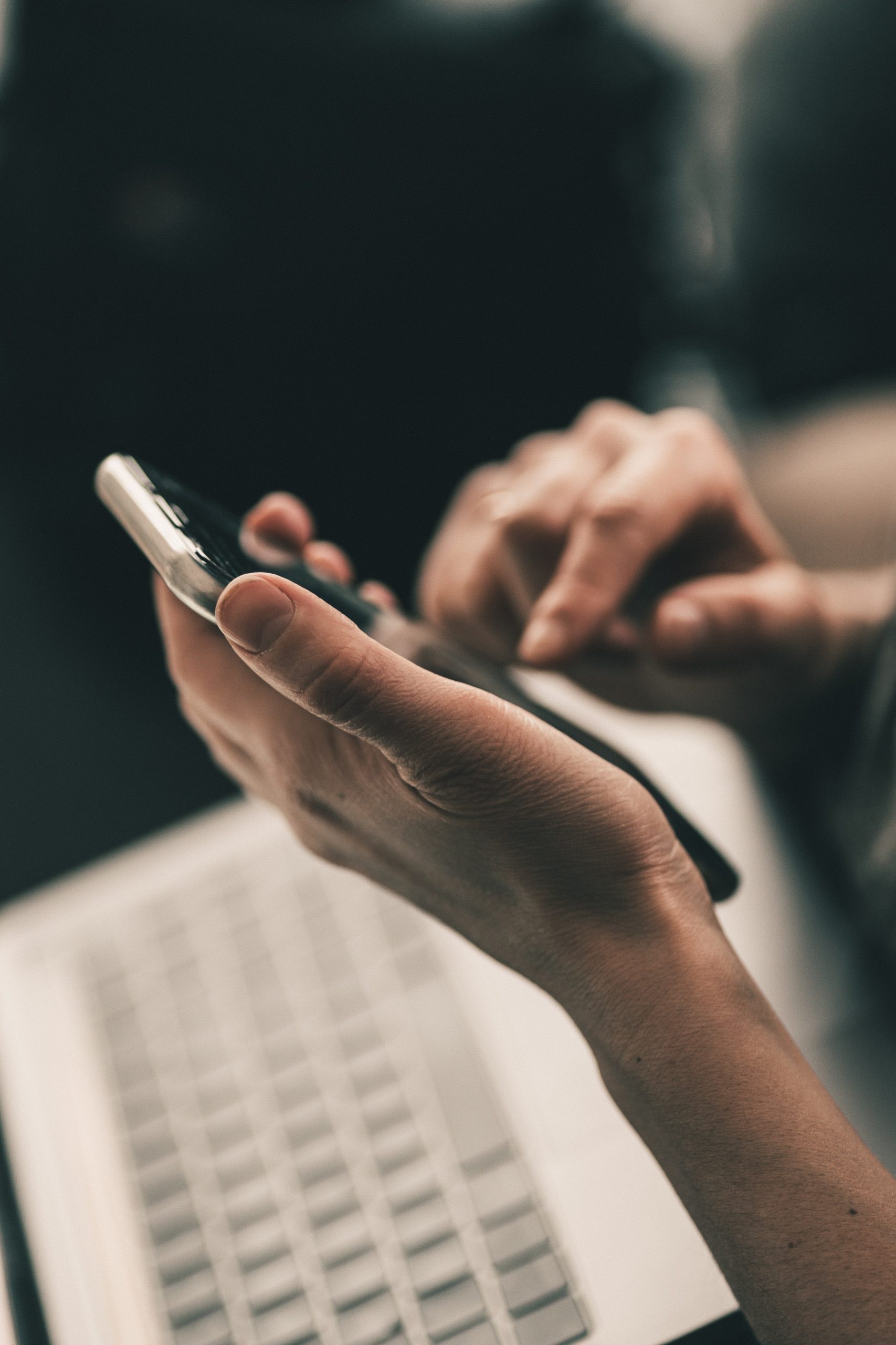 Closeup of hands holding iPhone using touchscreen